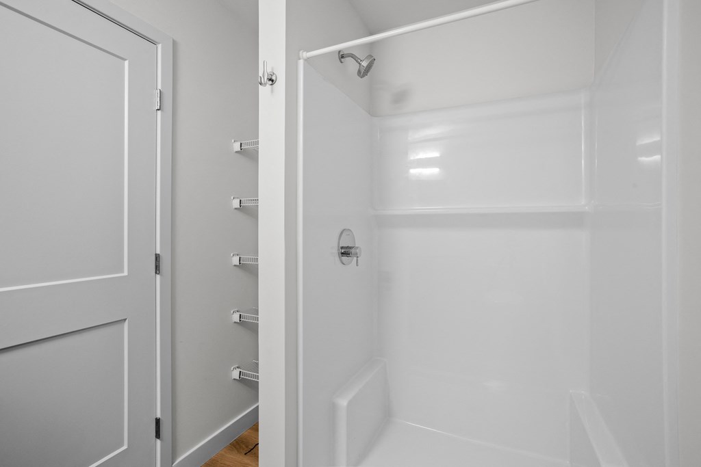 a white bathroom with a shower and a door