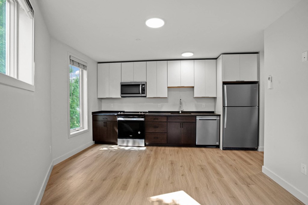 a kitchen with white cabinets and a stainless steel refrigerator