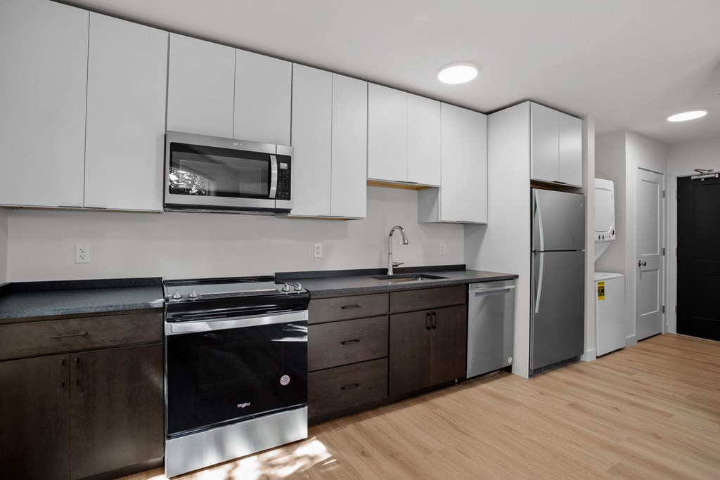 a kitchen with white cabinets and stainless steel appliances and a refrigerator