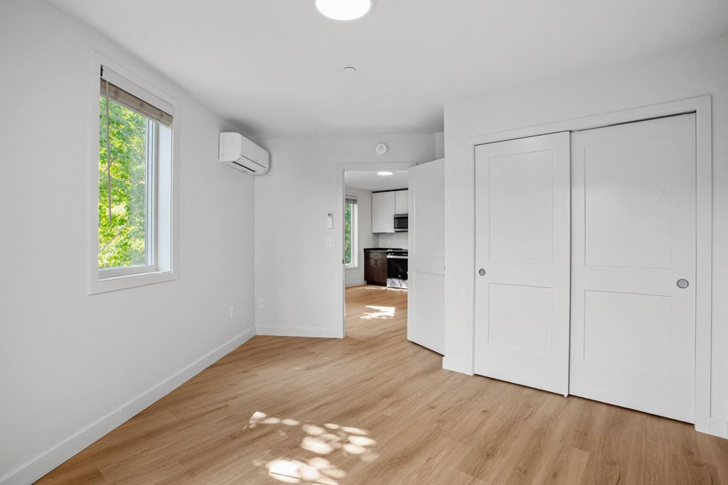 a renovated living room with white walls and wood floors