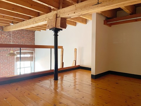 a living room with wood floors and exposed beams
