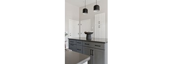 A kitchen with a bowl of fruit on the counter.