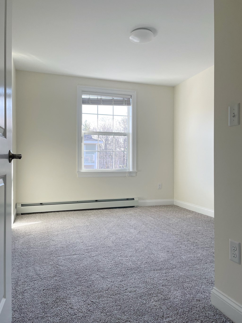 an empty room with carpet and a window