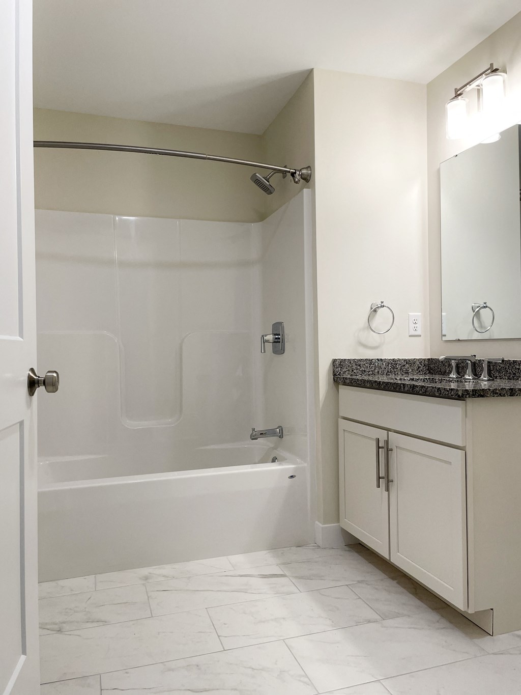 a bathroom with a tub and a sink and a mirror