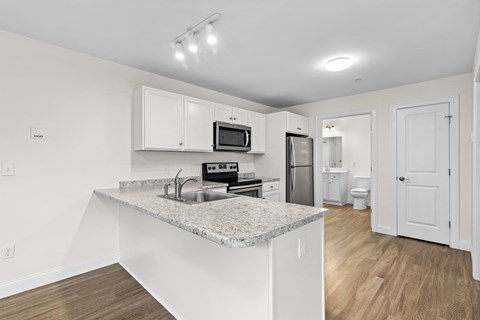 Kitchen with granite countertops and stainless appliances at Autumn Woods Apartments, Maine
