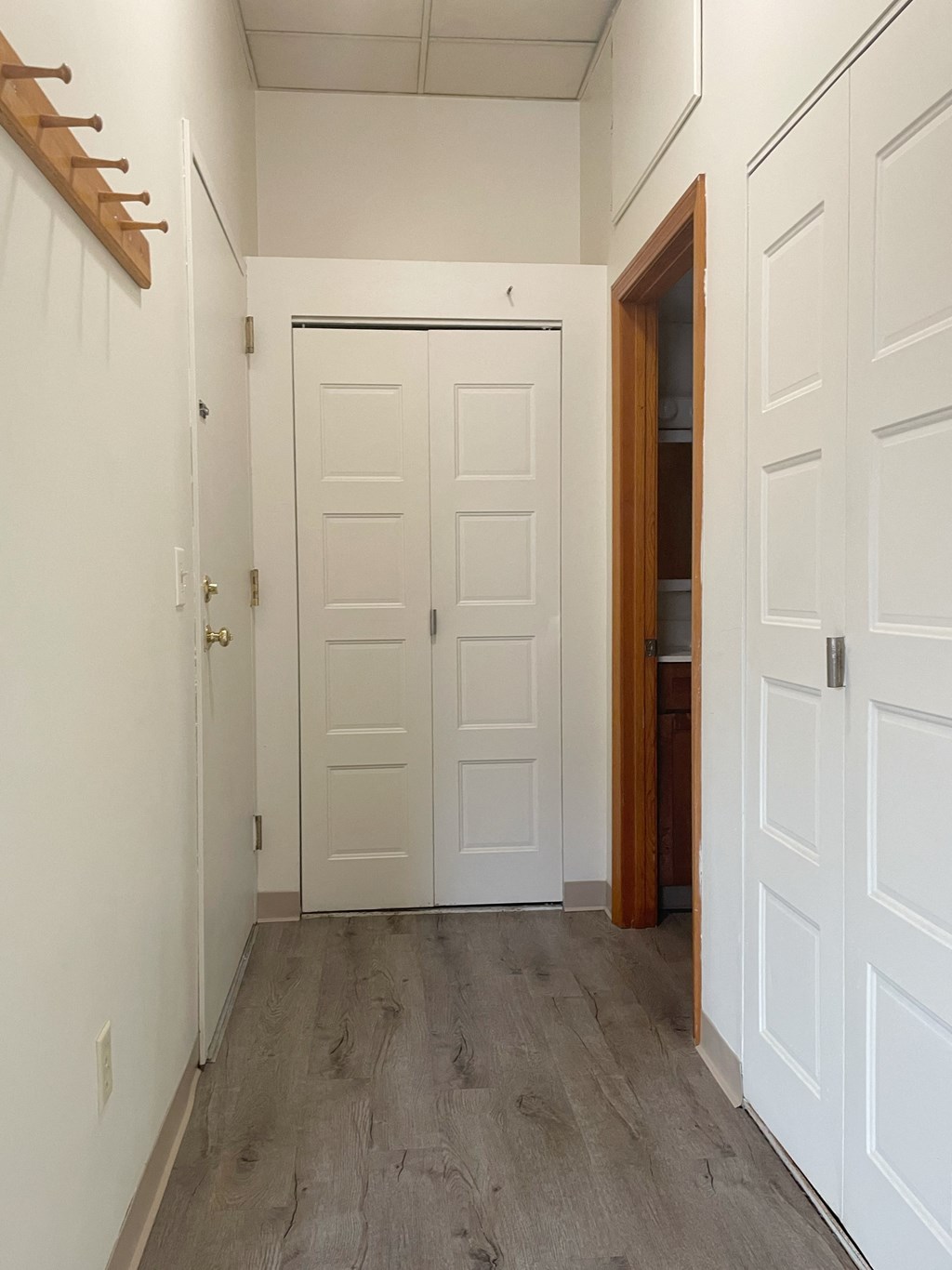 a bedroom with white doors and a hallway with wood floors