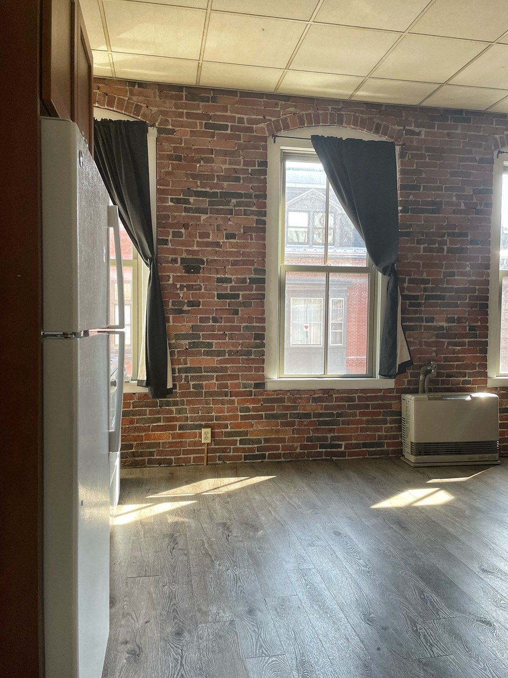 an empty room with a brick wall and a window