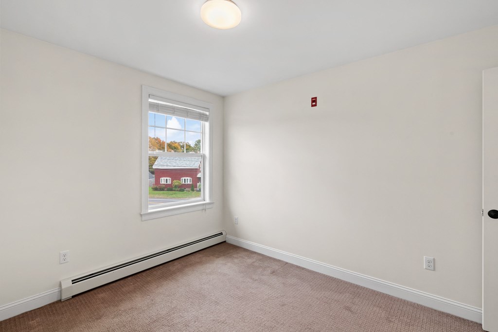 an empty room with a window and a red house