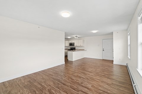 A room with wooden flooring and white walls.