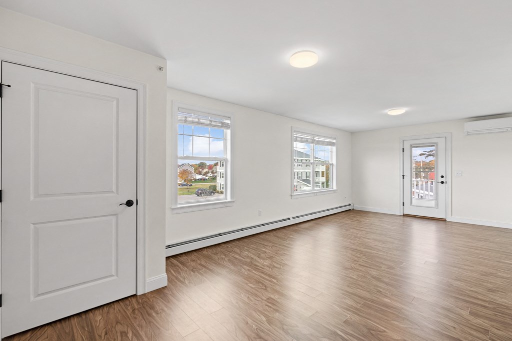 an empty living room with white walls and wood floors
