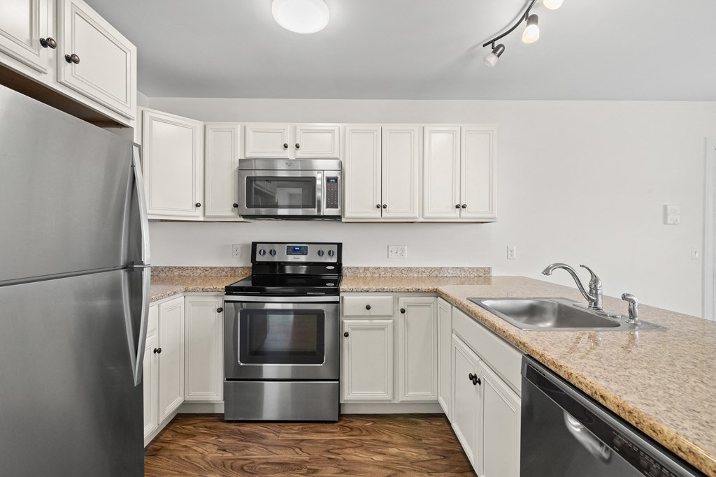 a kitchen with white cabinets and stainless steel appliances