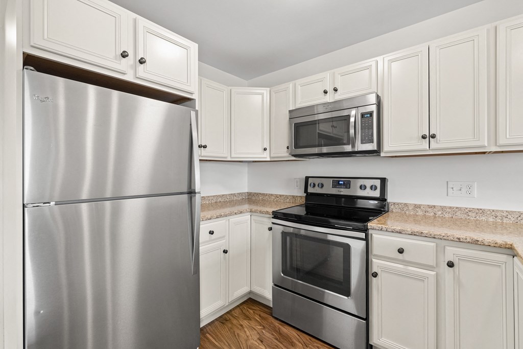 a kitchen with stainless steel appliances and white cabinets