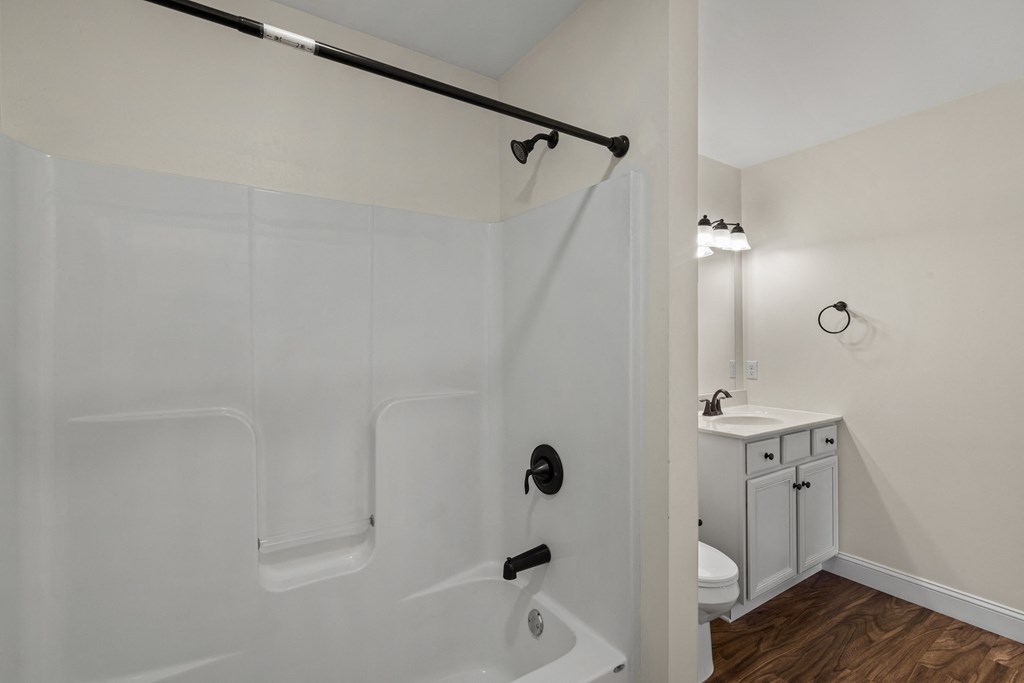 a bathroom with a shower and a sink and a toilet
