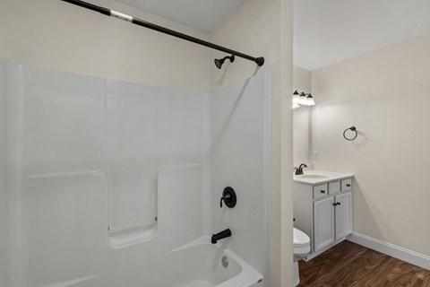 A white bathroom with a walk-in shower and a white sink.
