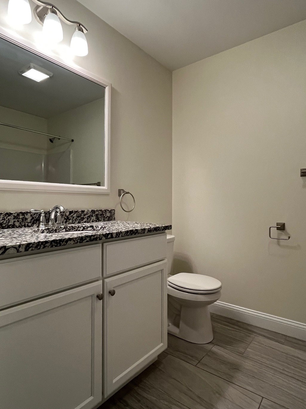 A bathroom with a marble countertop and a white toilet.