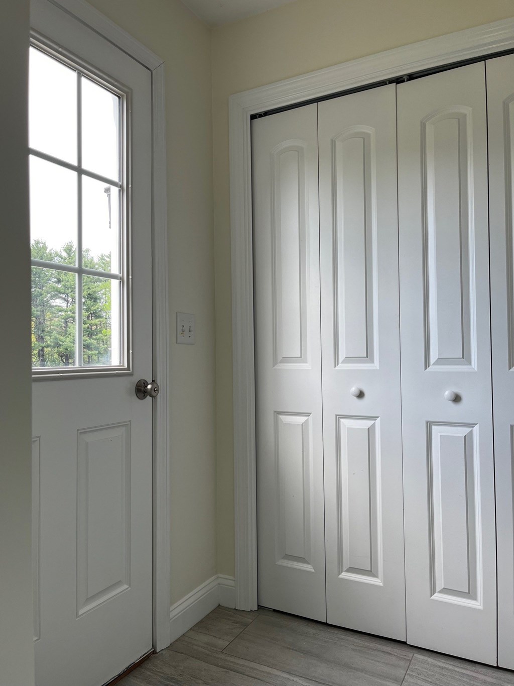 A white door is on the left and a white door with a black handle is on the right.