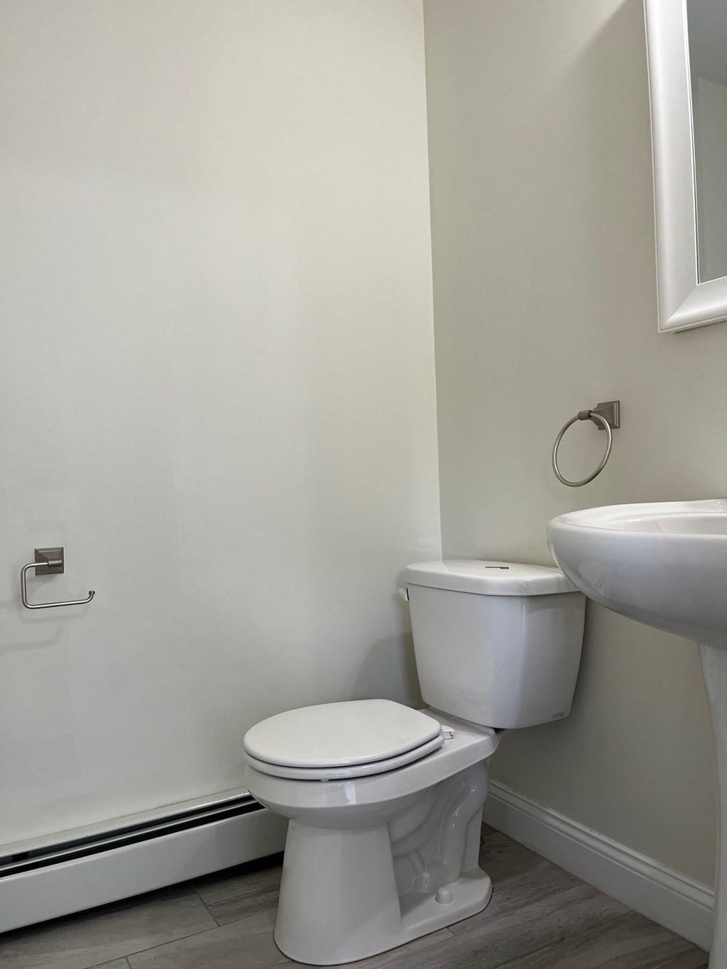 A white toilet sits next to a sink in a bathroom.