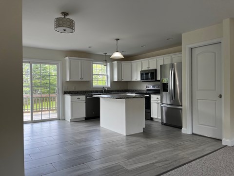 A kitchen with a large island and stainless steel appliances.