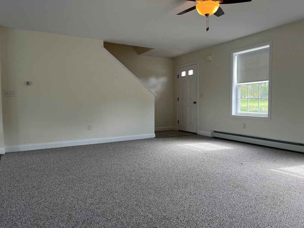 A room with a ceiling fan and a window.