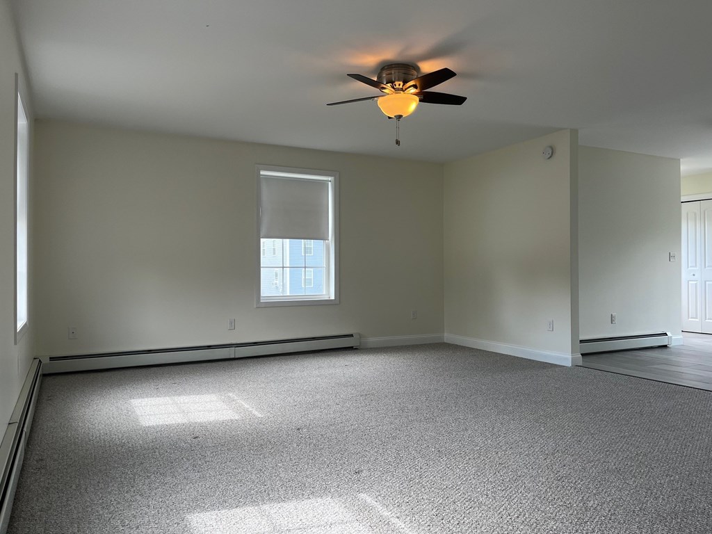 A room with a ceiling fan and a window.