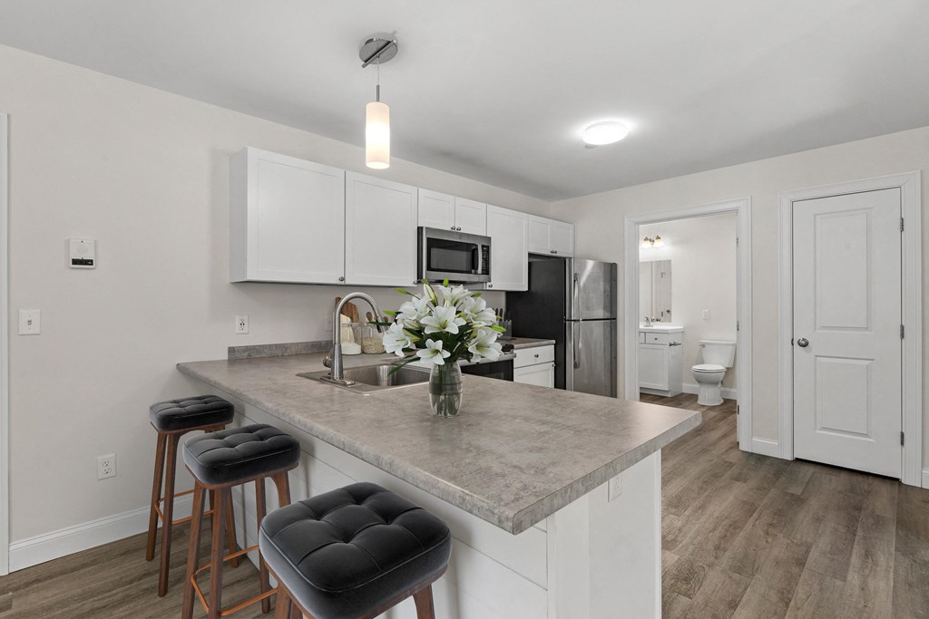 a kitchen with a marble counter top with three stools