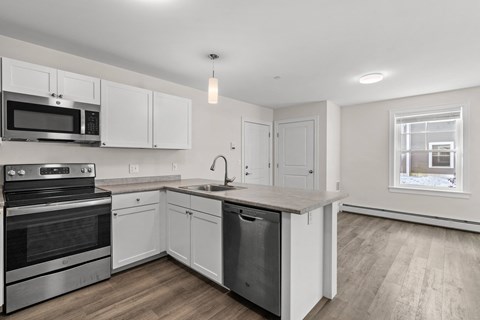 a renovated kitchen with white cabinets and stainless steel appliances