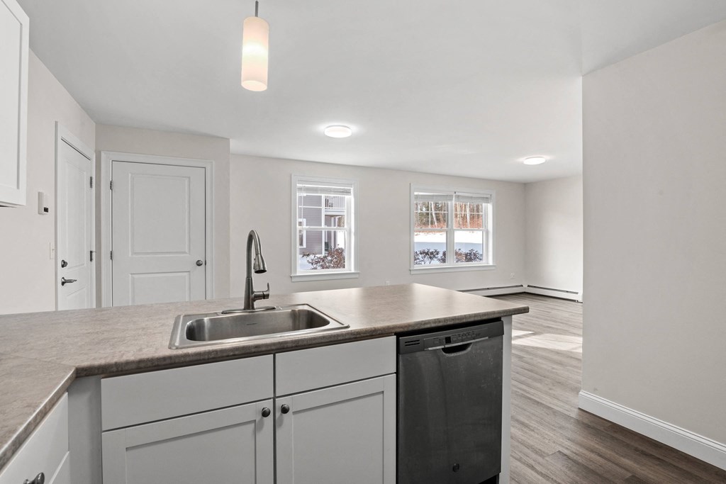 a renovated kitchen with white cabinets and a stainless steel sink