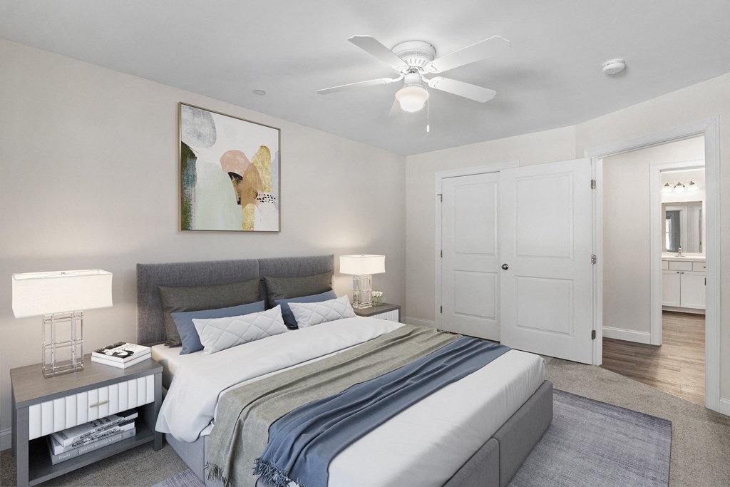 a bedroom with a large bed and a ceiling fan