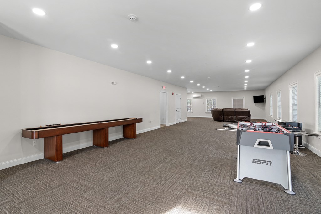 a game room with a pool table and a foosball table in the corner