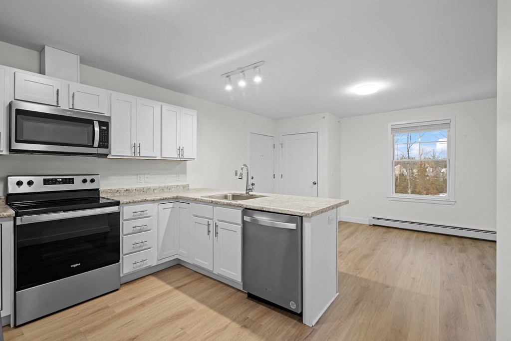 a kitchen with white cabinets and stainless steel appliances