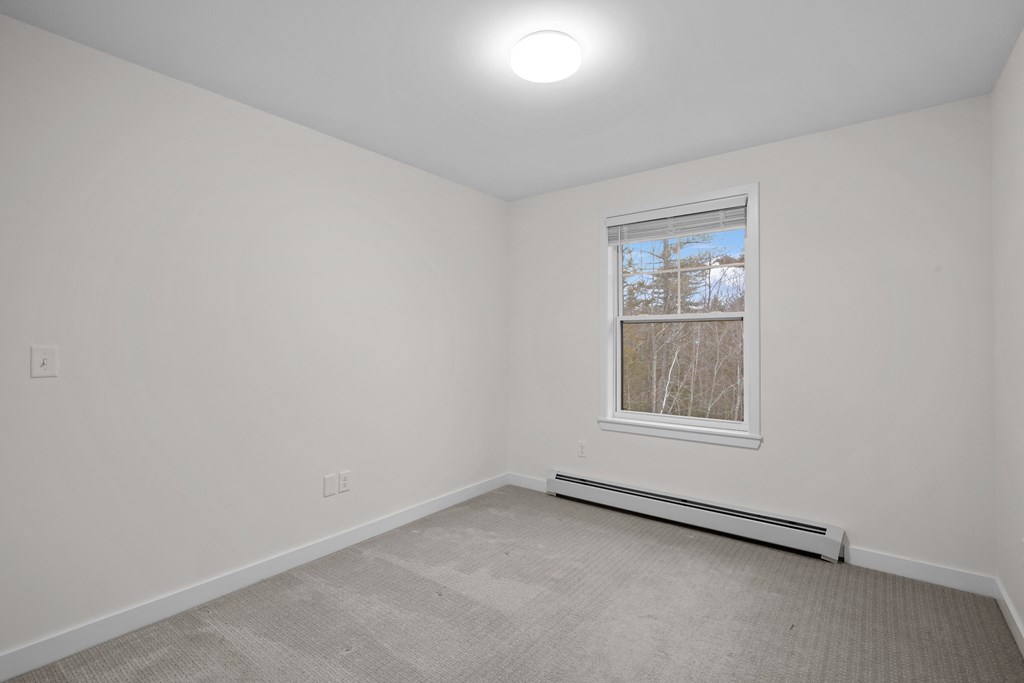 an empty room with white walls and a window