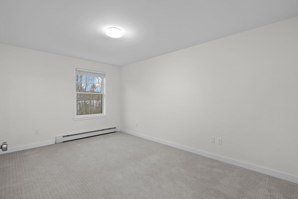 an empty living room with white walls and a window