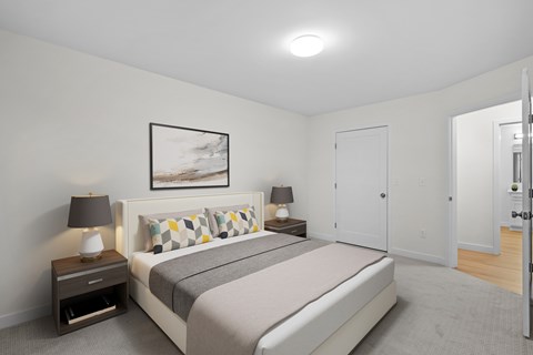 A bedroom with a bed, nightstands, and a painting on the wall.