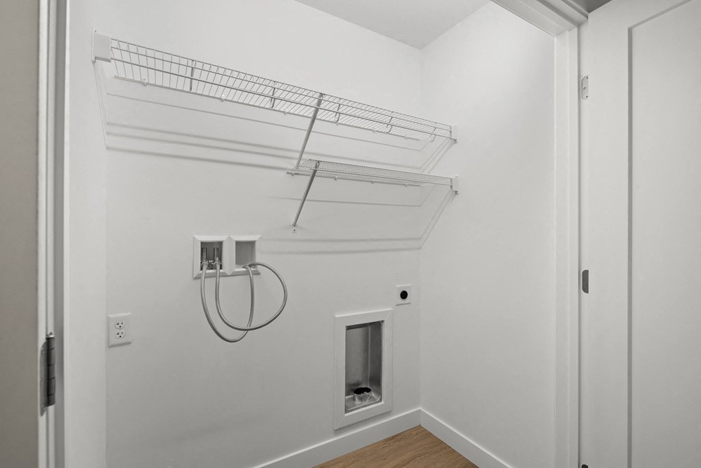 a bedroom with a white wall and a closet with a shelf on top of it