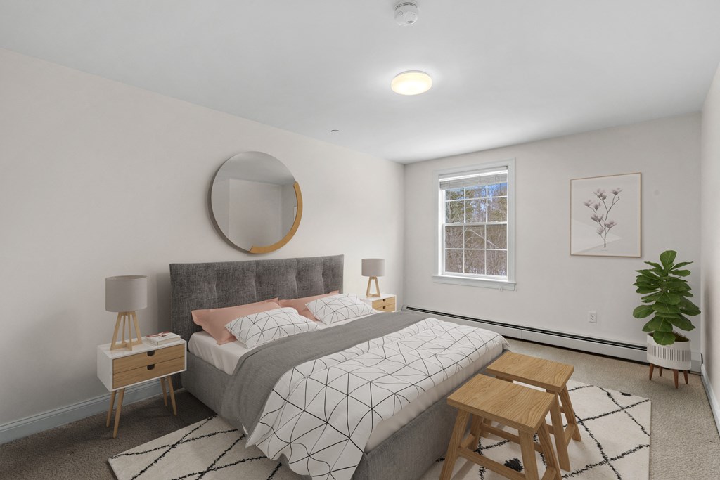 a bedroom with white walls and a gray bed
