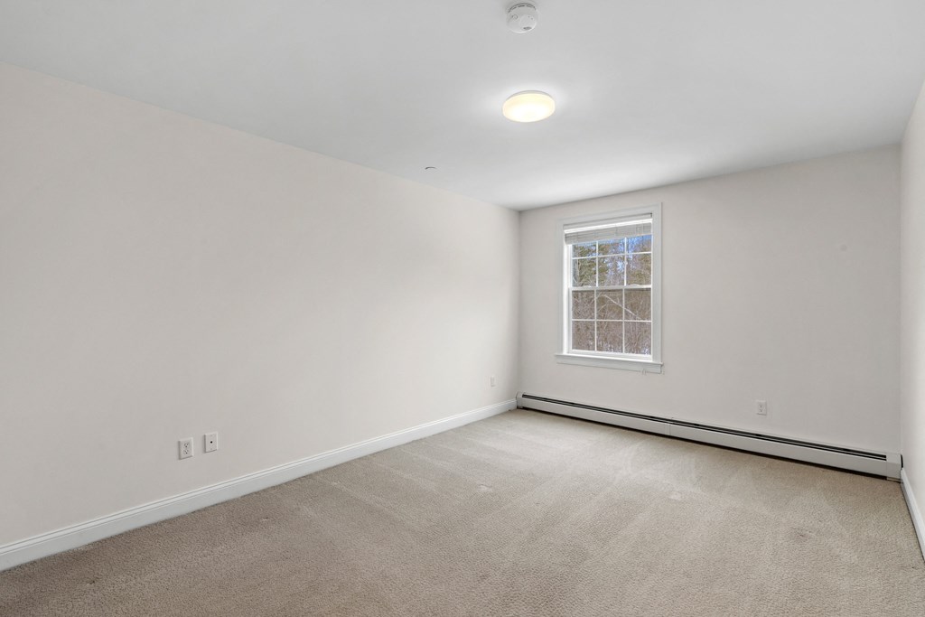 an empty room with white walls and a window
