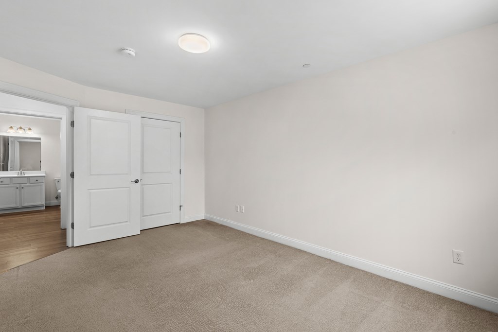 a bedroom with white walls and white doors and a carpet