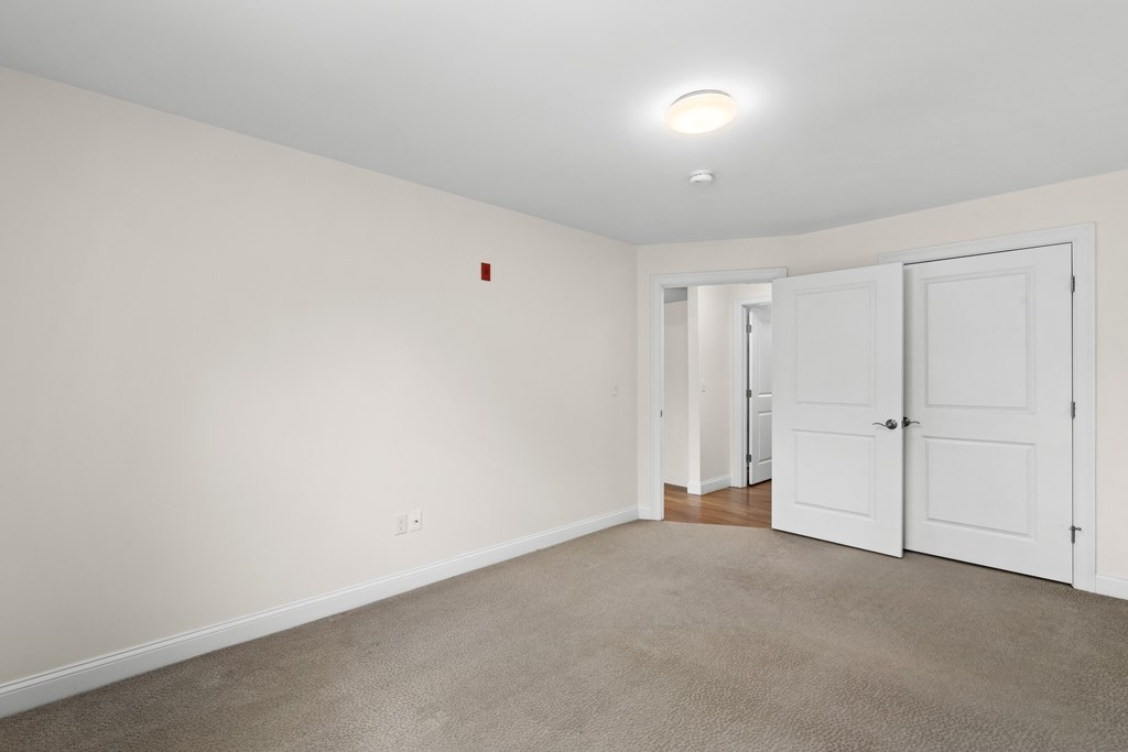 a bedroom with white walls and white doors and a carpeted floor
