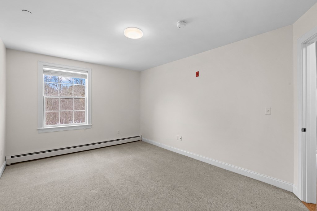 an empty room with white walls and a window