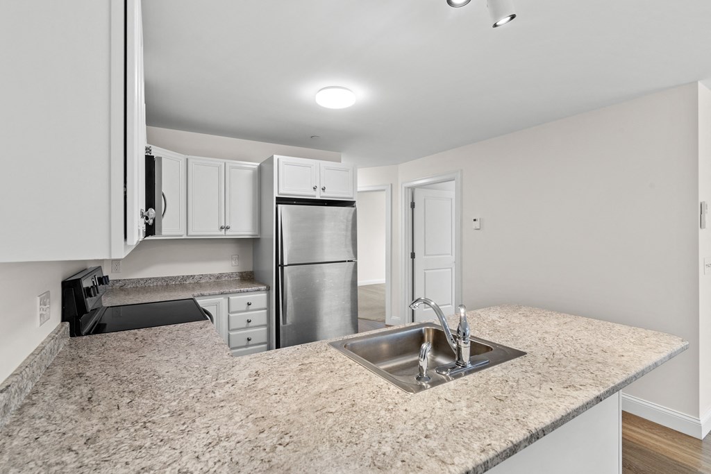 an empty kitchen with a sink and a counter top