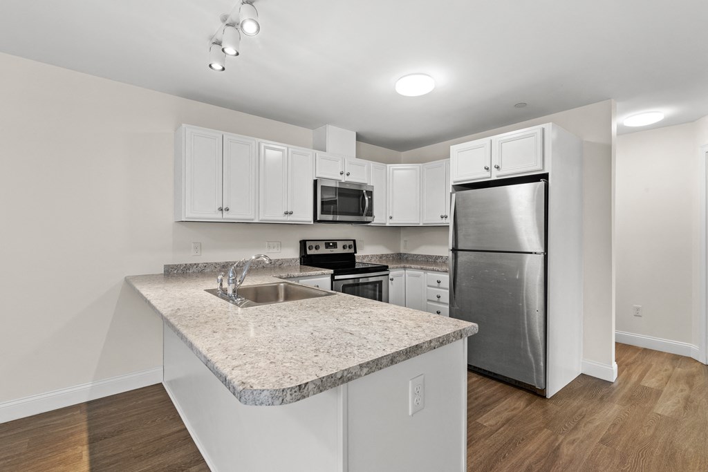 a kitchen with a granite counter top and a stainless steel refrigerator