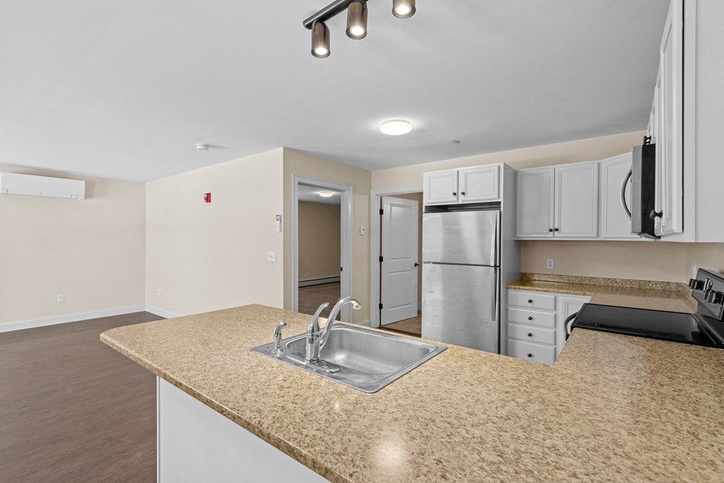 a kitchen with a granite counter top and a stainless steel refrigerator