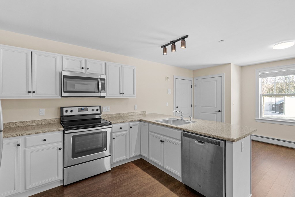 a kitchen with white cabinets and stainless steel appliances