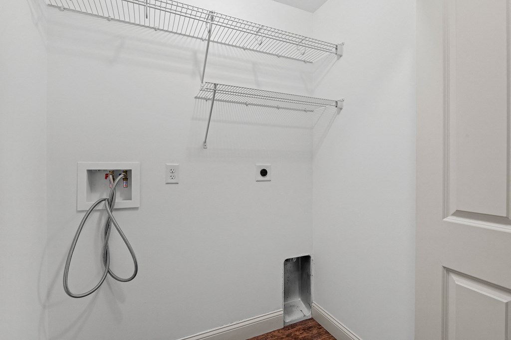 a room with a white wall and a white hose in it and a metal shelf