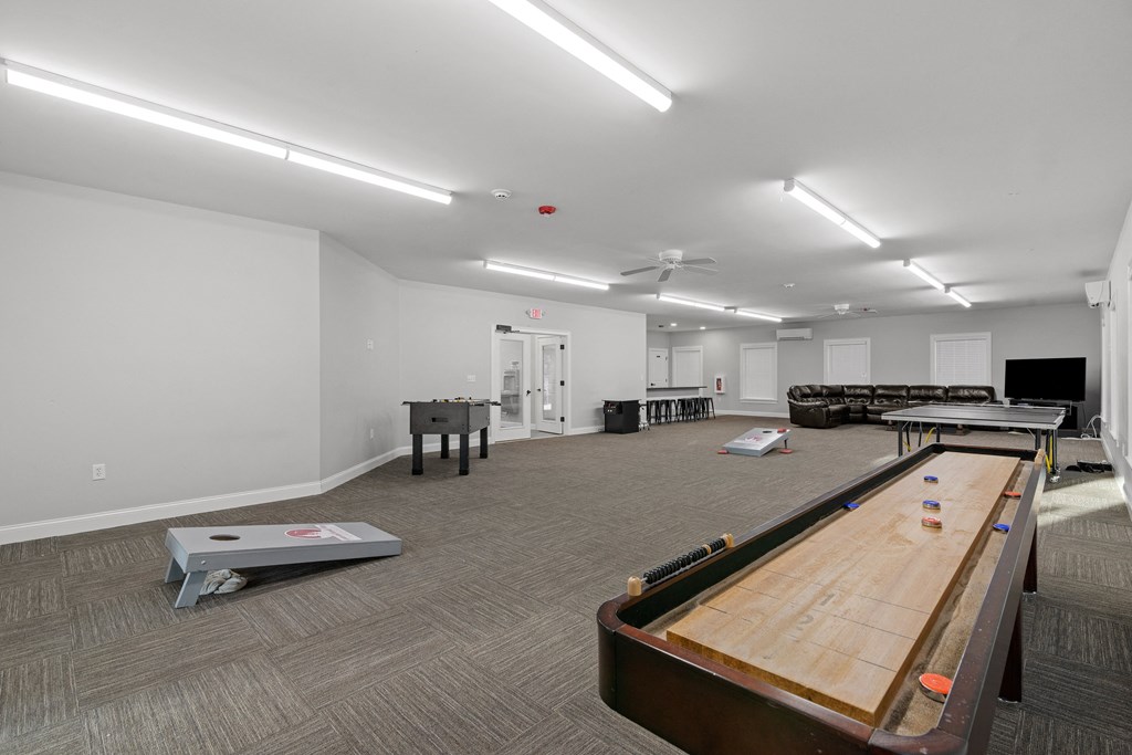 a game room with a shuffleboard table and a foosball