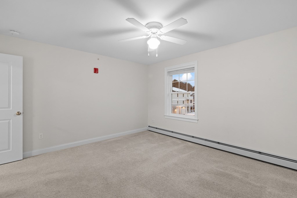 an empty room with a ceiling fan and a window