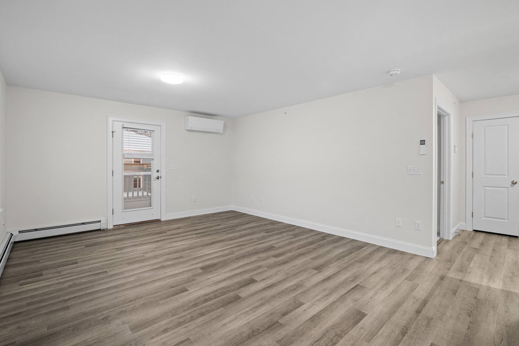 a living room with white walls and wood floors