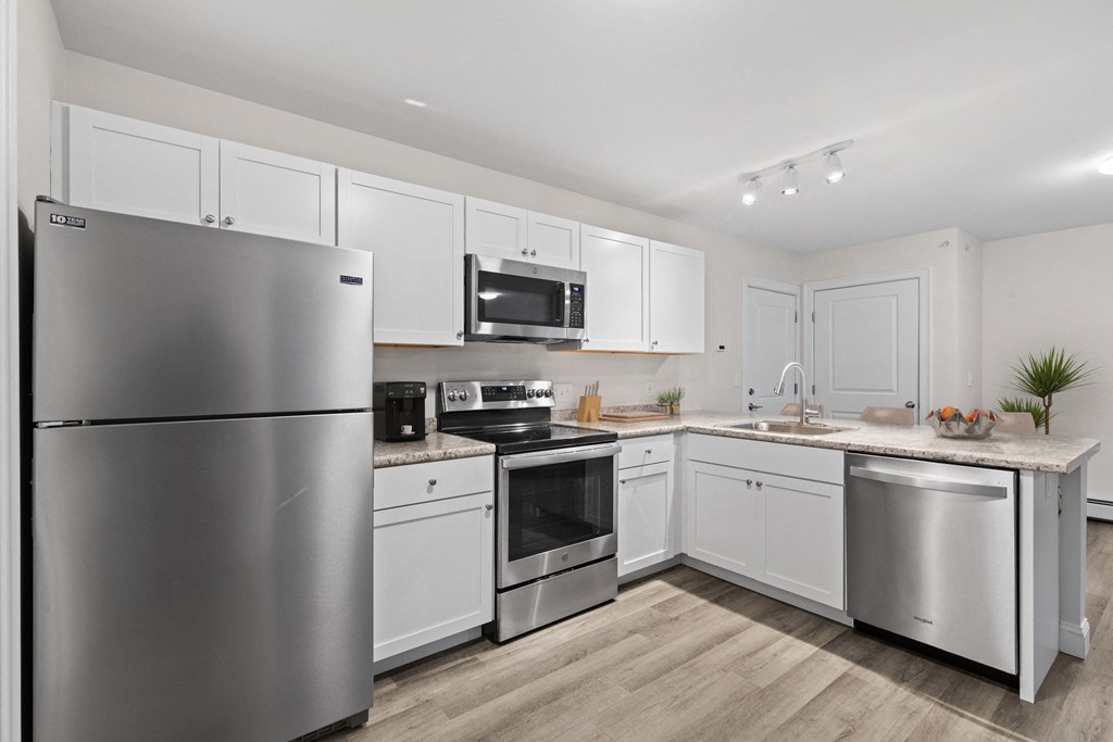 a kitchen with stainless steel appliances and white cabinets