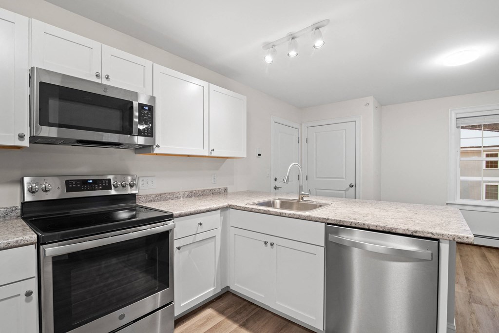 a kitchen with white cabinets and stainless steel appliances