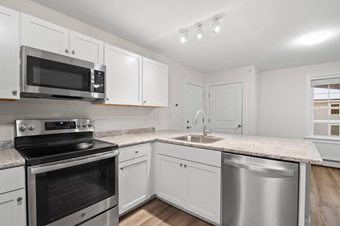 a kitchen with white cabinets and stainless steel appliances